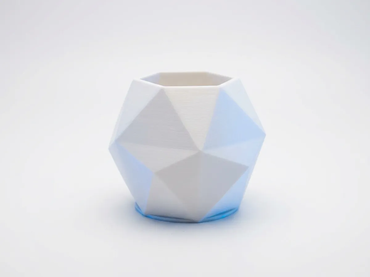 3D gedruckte dekorative geometrische Vase aus mattem weißem PLA-Kunststoff mit moderner Facettenstruktur.